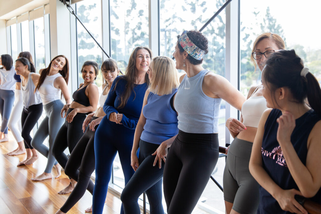 group of women laughing in a yoga studio